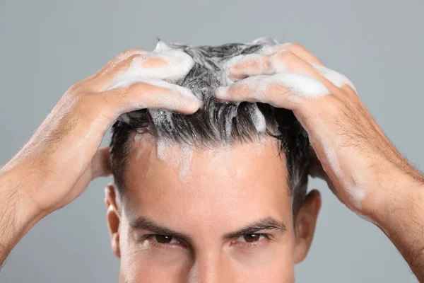 Przystojny Mężczyzna Myjący Włosy Szarym Tle Zbliżenie — Zdjęcie stockowe
