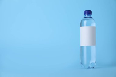 Açık mavi zemin üzerinde soda olan plastik şişe. Metin için boşluk