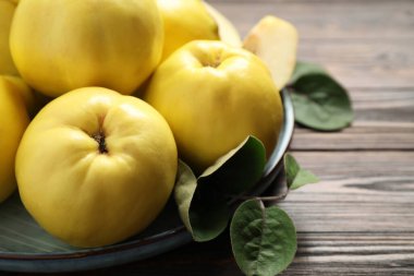 Tahta masa üzerinde yaprakları olan taze taze organik ayva, yakın plan.