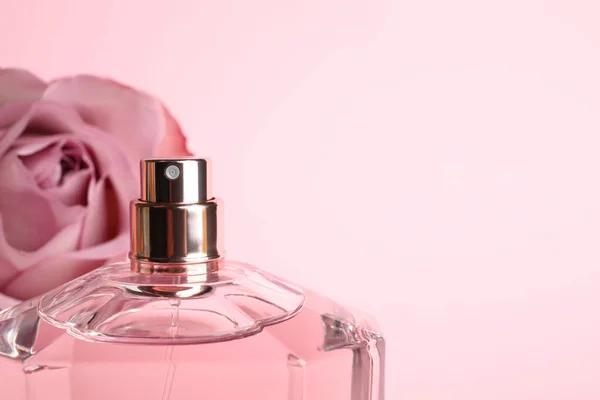 Eine Flasche Parfüm Und Eine Verschwommene Rose Auf Dem Hintergrund — Stockfoto