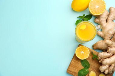 Açık mavi arka planda bağışıklık artırıcı içecekle düz kompozisyon. Metin için boşluk