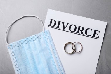 Düz kompozisyon, koruyucu maske ve gri masanın üzerinde alyanslar vardı. Koronavirüs karantinası sırasında boşan