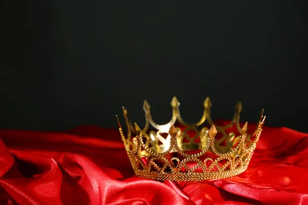赤い生地に美しい黄金の王冠 ファンタジーアイテム — ストック写真