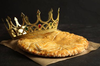 Geleneksel galette des Rois, siyah masada dekoratif taçla