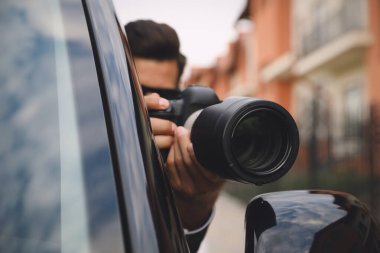 Kameralı özel dedektif arabadan gözetliyor, objektife odaklan.