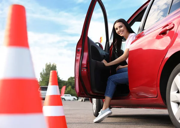 屋外の交通コーンの近くの車の中で若い女性 運転学校試験 — ストック写真