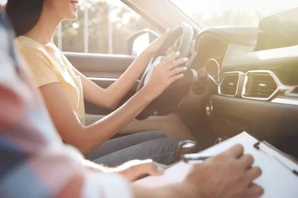 Young woman in car with instructor, closeup. Driving school