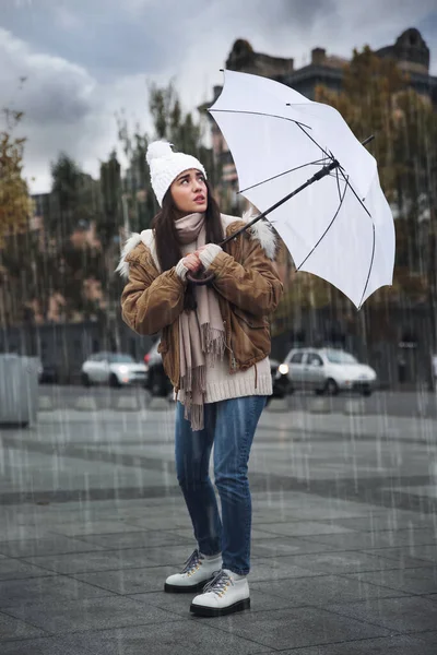 白い傘を差した女が路上で風に吹かれて — ストック写真