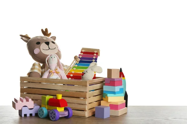 白色背景的木制桌子上有一套不同的玩具 — 图库照片