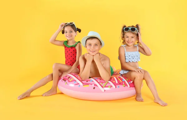 Söta Små Barn Strandkläder Med Ljusa Uppblåsbara Ring Gul Bakgrund — Stockfoto