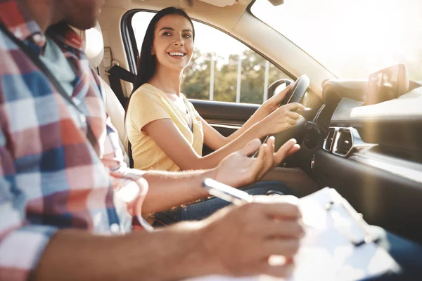 Young woman in car with instructor. Driving school