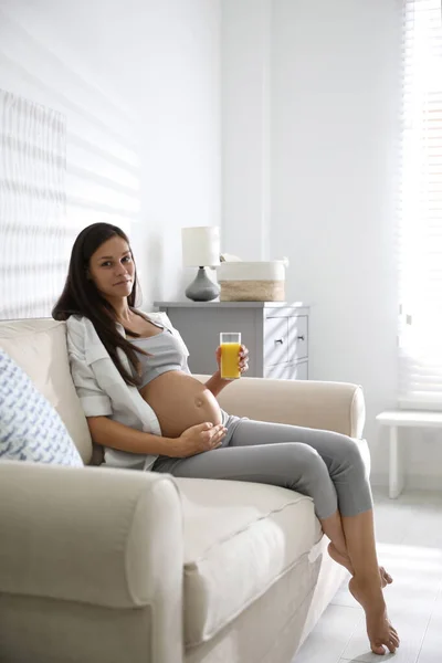 Een Jonge Zwangere Vrouw Met Een Glas Sap Woonkamer Zorgen — Stockfoto
