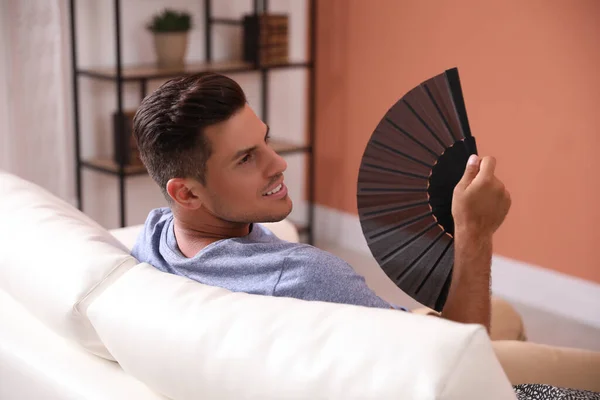 Hombre Con Ventilador Mano Sentado Sofá Temporada Verano — Foto de Stock