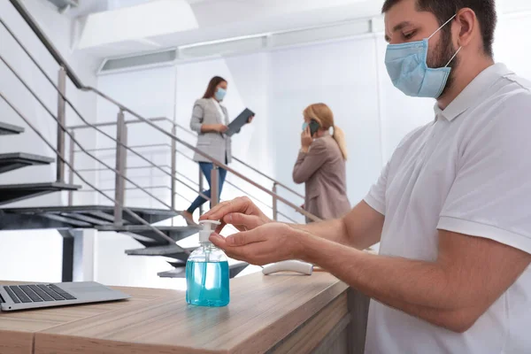 Hombre Aplicando Desinfectante Manos Recepción Oficina — Foto de Stock