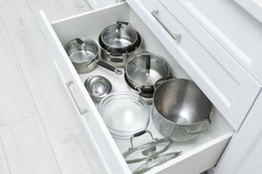 İçinde tencere ve tava olan açık bir çekmece. Mutfakta sipariş