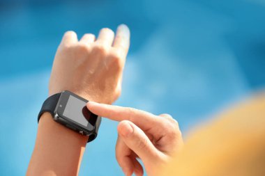 Modern akıllı saati kullanan kadın dışarıda, yakın plan.