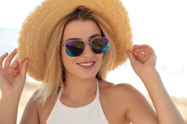 Güneşli bir günde güneş gözlüğü takan güzel bir kadın.