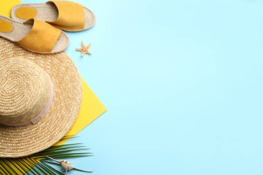 Açık mavi arka planda plaj aksesuarları, düz yatış. Metin için boşluk