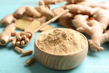 Kuru, kapsüllü ve açık mavi ahşap masada taze zencefil, yakın plan.