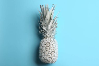Açık mavi arka planda beyaz ananas boyalı, üst manzara. Yaratıcı kavram