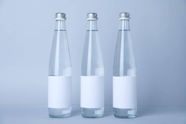 Açık arkaplanda soda olan cam şişeler.