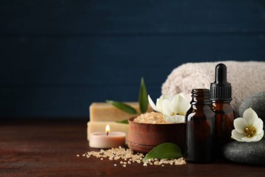 Cilt bakım ürünleri, spa taşları ve ahşap masa üzerinde aroma yağı olan kompozisyon. Metin için boşluk