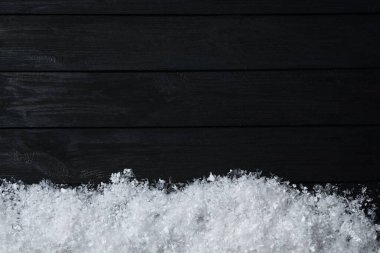 Siyah ahşap arka planda yazı için kar ve boşluk, üst manzara. Noel zamanı