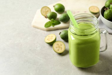 Mason kavanozunda taze feijoa smoothie. Işık masasında, yakın plan. Metin için boşluk