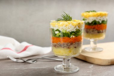 Geleneksel Rus salatası Mimosa gri masada servis edilir.
