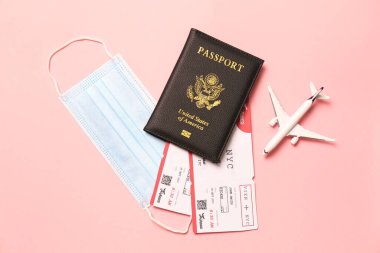 Pembe arka planda pasaport ve koruyucu maskeli düz kompozisyon. Karantina sırasında seyahat