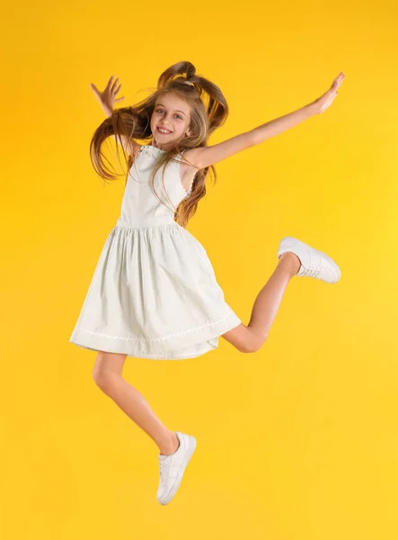 Menina Bonito Pulando Fundo Amarelo — Fotografia de Stock