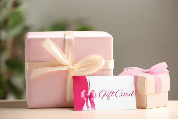Gift card and present on table against blurred background