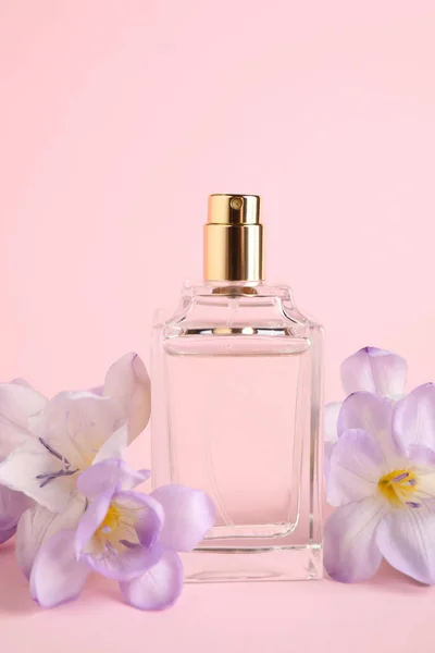 Eine Flasche Parfüm Mit Freesiablüten Auf Rosa Hintergrund — Stockfoto