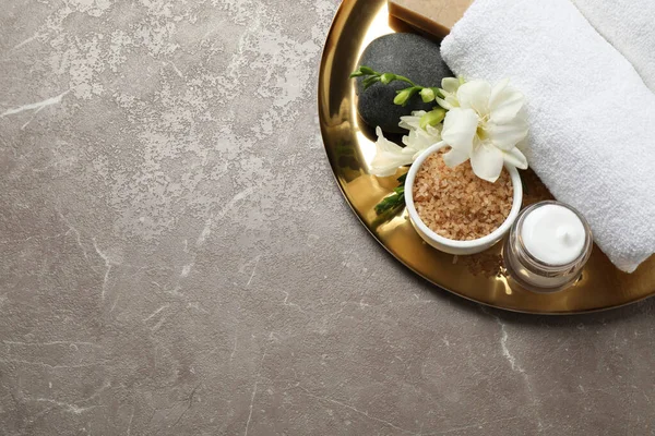Gri mermer sehpanın üzerinde spa malzemeleri olan tepsi, üst manzara. Metin için boşluk
