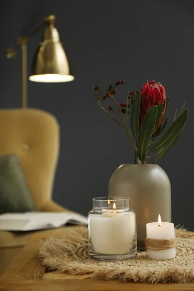 Wazon Pięknych Kwiatów Protea Płonące Świece Drewnianym Stole Pomieszczeniach Elementy — Zdjęcie stockowe