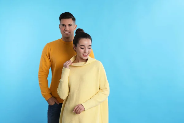 Pareja Feliz Usando Suéteres Cálidos Amarillos Sobre Fondo Azul Claro — Foto de Stock