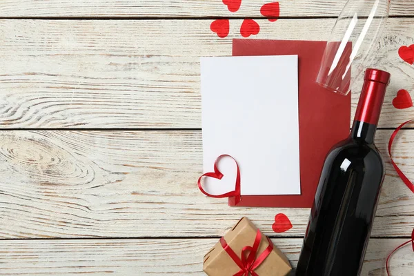 Düz kompozisyon, beyaz ahşap zemin üzerinde boş kart, metin için boşluk. Sevgililer Günü kutlaması
