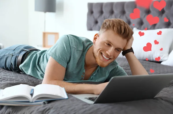 Young man visiting dating site via laptop indoors