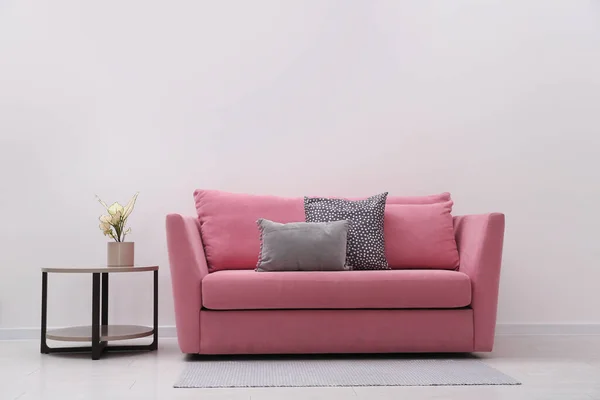 Simple room interior with comfortable pink sofa, space for text