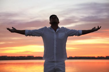 Gün batımında nehrin yanında bir adam. Doğa iyileştirme gücü