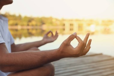 Gün batımında nehrin yanında bir adam var, yakın plan. Doğa iyileştirme gücü