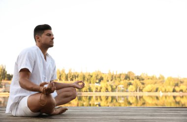 Gün batımında nehrin yanında bir adam, mesaj için yer. Doğa iyileştirme gücü