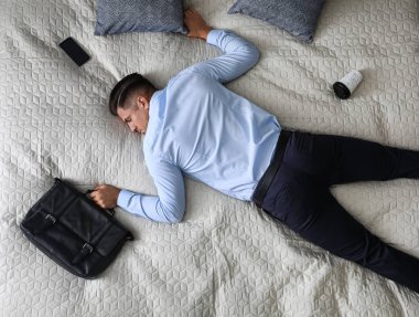 Ofisteki bitkin iş adamı işten sonra evde, manzaranın üstünde uyur.