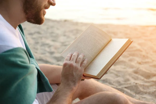 Молодой Человек Читает Книгу Песчаном Пляже Крупным Планом — стоковое фото
