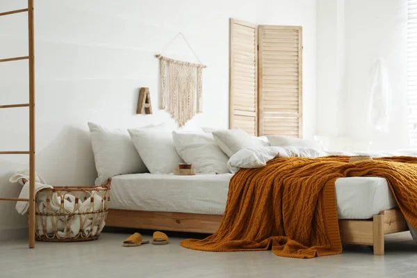 舒适的床与温暖的针织格子布在时尚的房间内部 — 图库照片