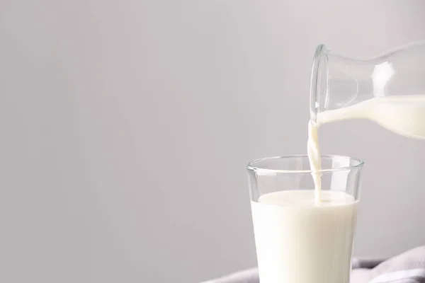 Melk Glas Gieten Een Grijze Achtergrond Ruimte Voor Tekst — Stockfoto