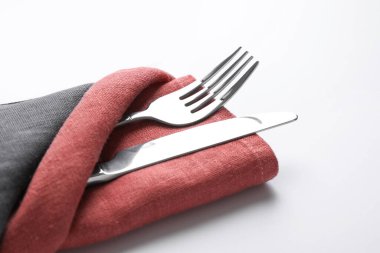 Çatal ve bıçakla katlanmış peçete beyaza izole edilmiş, yakın plan