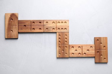 Açık gri masada tahta domino taşları, düz yatıyordu.