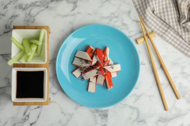 Fresh crab sticks with soy sauce and celery served on white marble table, flat lay clipart