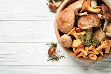 Beyaz ahşap masa üzerinde farklı taze mantarlar, düz yatış. Metin için boşluk